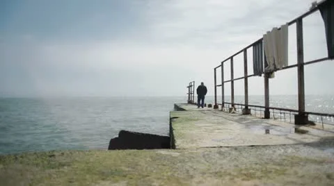 Lonely elderly man walking on the beach Stock Footage 22415813