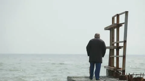 Lonely elderly man walking on the beach Stock Footage 22415817