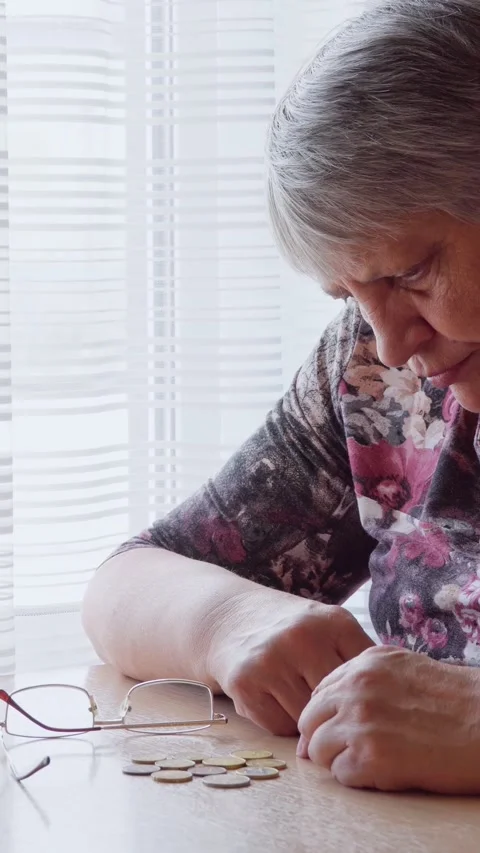 A lonely elderly woman longingly counts small money, coins in euros. Stock Footage 293138305