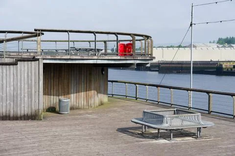 Lonely empty bench at the River Clyde in Govan for mindfulness and meditation Stock Photos
