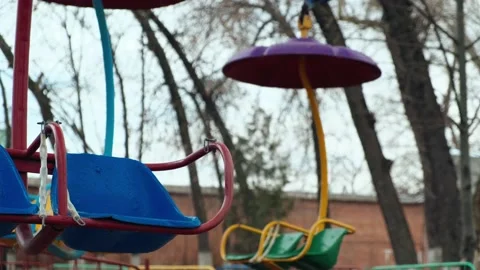 Lonely empty deserted swing in an old abandoned amusement park. Swinging seat Video stock 151924930