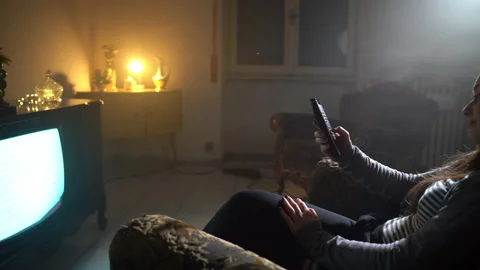 Lonely evening in old dark illuminated room of woman sitting on the armchair and Video stock 202170679
