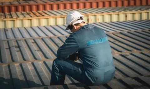 Lonely Foreman worker lost in depression on the containers box in the cargo Stockfoto's