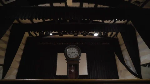A lonely grandfather clock performs on the empty theater stage surrounded Stock Footage 113035272