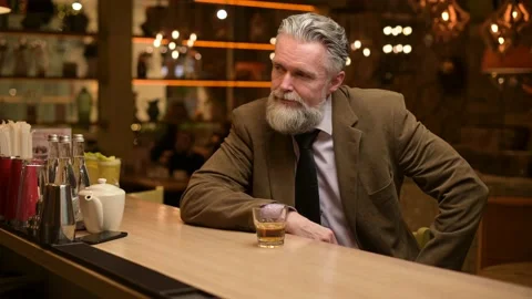 Lonely gray-haired man drinking whiskey at a bar Stock Footage 154878702