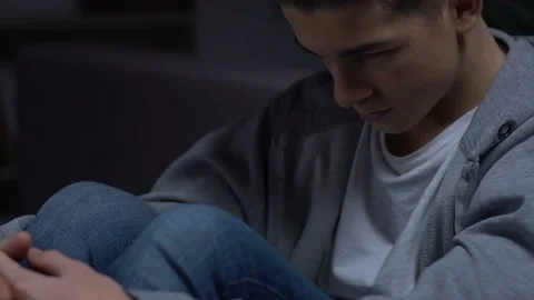 Lonely guy sitting alone in his room, anxiety of introverted person, depression Stock Footage 103401476