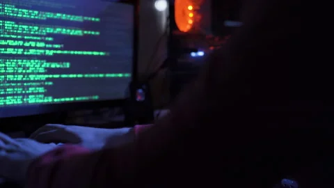 Lonely hacker programmer surrounded by programming codes interface in a dark Video stock 220160690