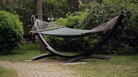 A lonely hammock swinging in the wind in the forest or Park. Stock Footage 100892465