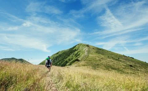 Lonely hiker walking by the mountain path Stock Photos