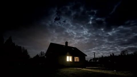 Lonely house under cloudy sky at night. Moon over house. Video stock 244515507