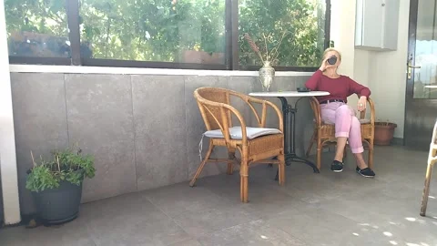 The lonely lady opens the thermal cup and enjoys drinking her coffee Stock Footage 332505105