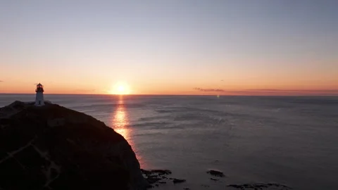 A lonely lighthouse on the ocean at dawn Stock-Footage 266932355