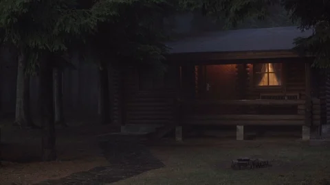 Lonely log cabin with warm glowing windows in the night in spooky,misty, scary Stock Footage 119385270