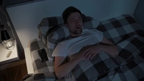 Lonely man cannot sleep in bed at night with eyes wide open, staring at ceiling Stock Footage 155004507