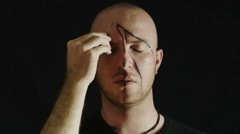 Lonely man in the darkness makes black signs over his face: sad, opening eyes Stock-Footage 42434042