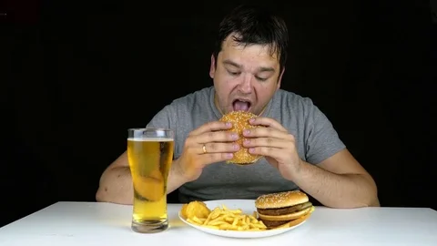 Lonely man eating hamburger Stock Footage 77593607