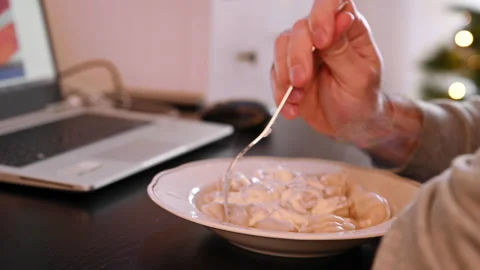 Lonely Man eats dumplings with sour cream and looks online in a laptop. 스톡 동영상 144058975