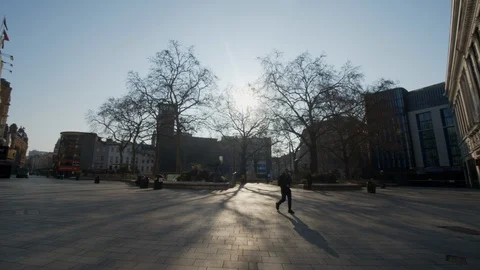 Lonely man on Empty Leicester square during Covid - 19 Lockdown Stock Footage 127697401