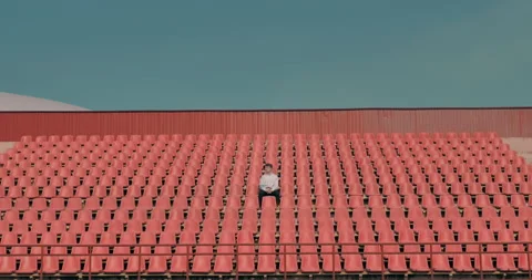 Lonely man on the empty stadium applauds the players and rejoices at the victory 库存影片 135325947
