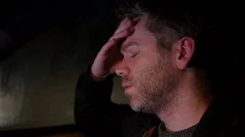 A lonely man feeling sad and alone in a car at night. He is upset after Stock Footage 220940179