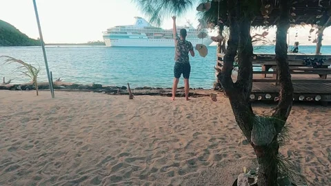 A lonely man on an island waves hello to a cruise ship Stock Footage 257544586