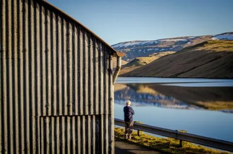 Lonely man by lakeside Stock Photos