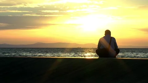 Lonely man at seaside in sunset time Stock Footage 68893197
