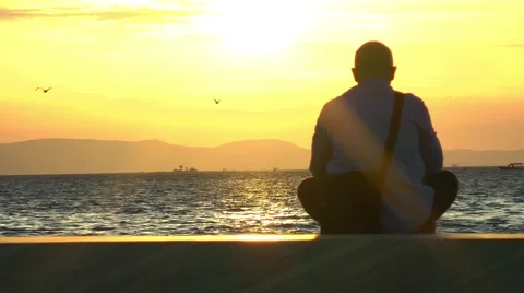 Lonely man at seaside in sunset time Stock Footage 68893255