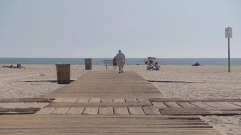 A Lonely Man Sits at a Bench on the Beach Thinking Video stock 90585739