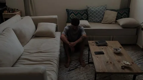 Lonely man sitting on floor alone in empty living room Stock Footage 346244159