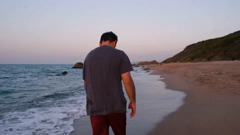 Lonely man walking on the beach Stock Footage 238405836