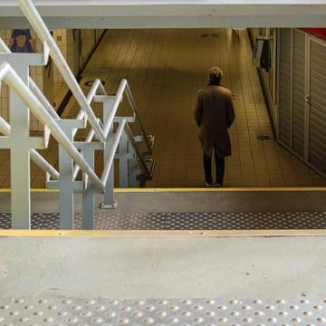 Lonely man walking through underground pedestrian tunnel Stock Photos