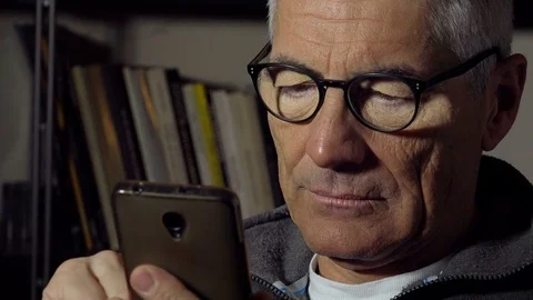 Lonely mid aged man texting messages on a mobile phone with touchscreen Stock Footage 74431187