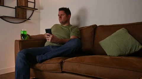 Lonely middle aged man bored on St Patrick's day looking for answer on phone Stock Footage 233020338