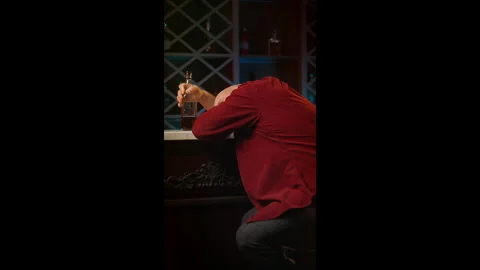 Lonely middle-aged man sleeps with liquor bottle at bar counter, alcoholism Stock Footage 346714379