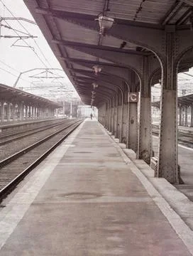 Lonely moody scene with an empty train station or railway platform on a foggy Foto stock