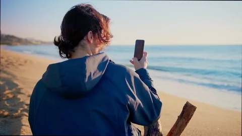 Lonely nostalgic man making a picture or photo of sunrise or sunset sky and sea Video stock 100896028