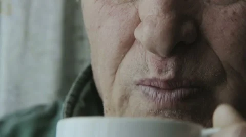 Lonely old man deep in his problems and drinking coffee or tea Video stock 48058636