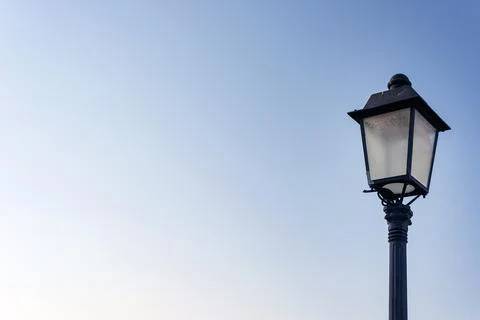 Lonely old styled lantern on a clear sky background Stock Photos