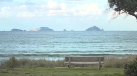 Lonely park bench with ocean backdrop HD Stock Footage 65626273