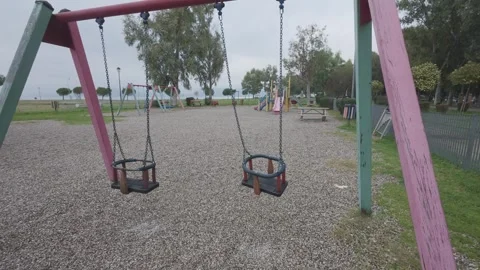 Lonely playground swing in quiet park with cloudy weather Stock Footage 338105848