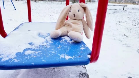 Lonely rabbit doll sitting alone on carousel at winter. Stock Footage 221305287