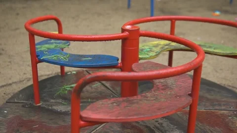 Lonely red empty deserted swing in an old abandoned amusement park. Swinging Stock Footage 155010544