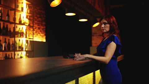Lonely red-haired woman drinking cocktail alone at bar counter, feeling sad Stock Footage 312752553