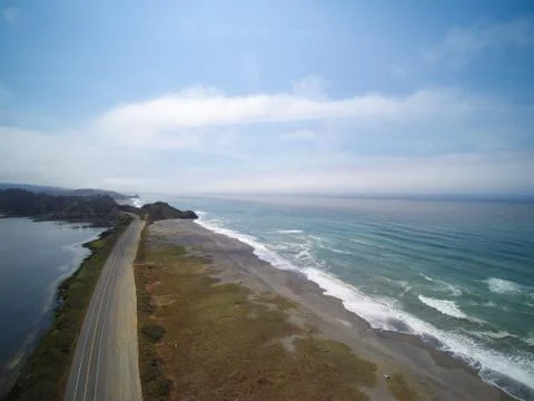 Lonely road between mountain lake and ocean shore, aerial view Stock Photos