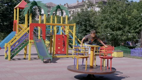 Lonely, Sad Child Rotationing on Empty Carousel During Quarantine at Playground 動画素材 158883955
