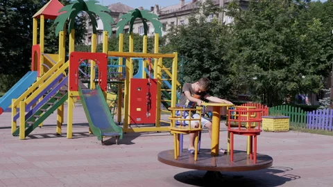 Lonely, Sad Child Rotationing on Empty Carousel During Quarantine at Playground 動画素材 158891135