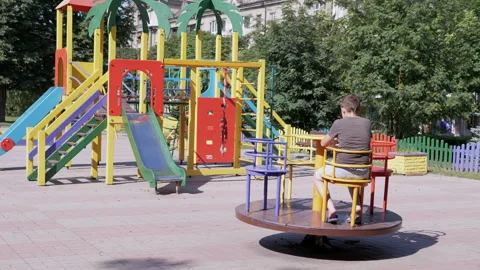 Lonely, Sad Child Rotationing on Empty Carousel During Quarantine at Playground 動画素材 158947129