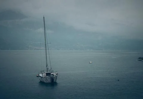 Lonely Sailing Ship with Mountain Backdrop on Garda Lake Italy Stock Photos