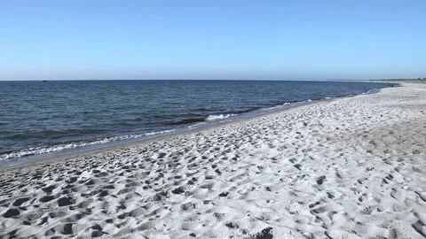 Lonely sandy beach on the baltic coast. Blue sky, bright sun. Small sea waves. Stock Footage 155096726